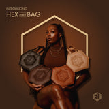 A person poses confidently with a collection of four handbags in various shades of eumelanin brown. The background is a warm, dark brown with geometric accents. Text reads Introducing HEX mini BAG. Ready to shop?.